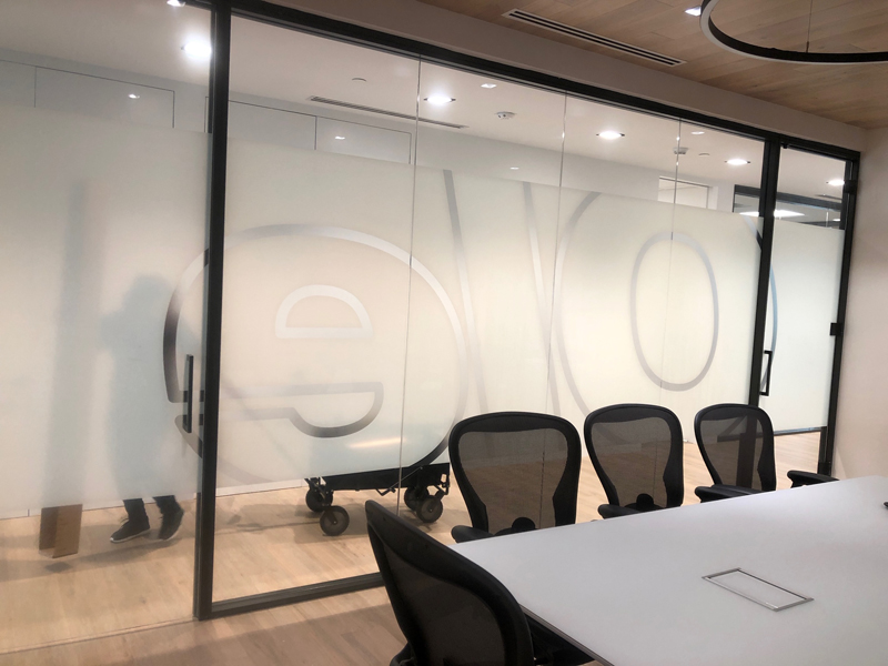 Logo of Ole Network on frosted glass wall inside an office